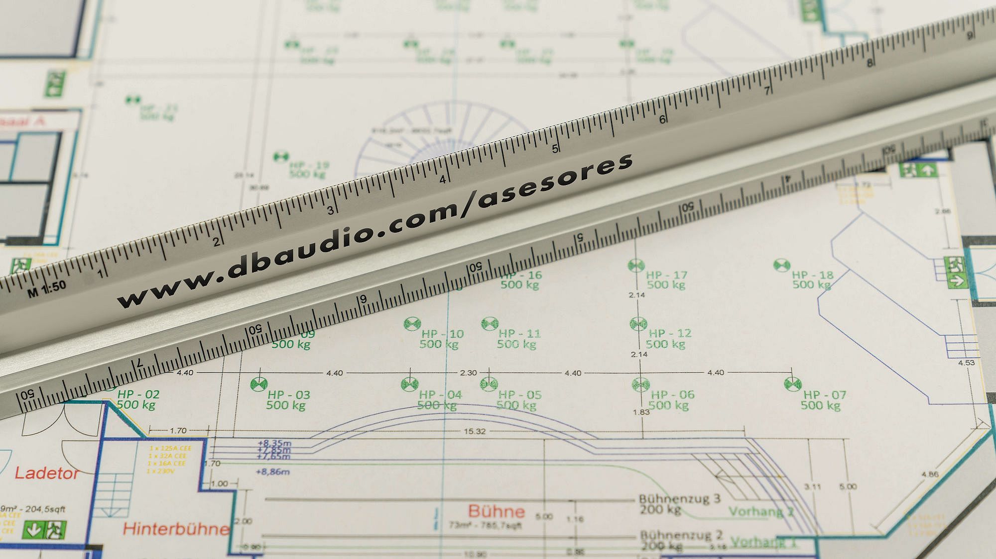Blueprint with measurements and annotations, featuring a ruler placed across the design, indicating technical details for a space layout.