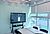 A large digital display shows a colorful data visualization in a modern conference room with a table and chairs.