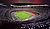 A panoramic view of a modern soccer stadium featuring a well-maintained pitch and empty seating areas.