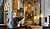 Interior of a church featuring a decorative pulpit, stained glass windows, and an ornate altar with religious artwork.