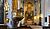 Interior of a church featuring a decorative pulpit, stained glass windows, and an ornate altar with religious artwork.