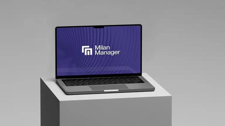 Ein Laptop, der das Logo des 'Milan Managers' auf einem lila Hintergrund zeigt, steht auf einem grauen Podest.