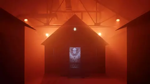 Three dark structures are illuminated by orange lights in a foggy environment, with a central door featuring intricate designs.