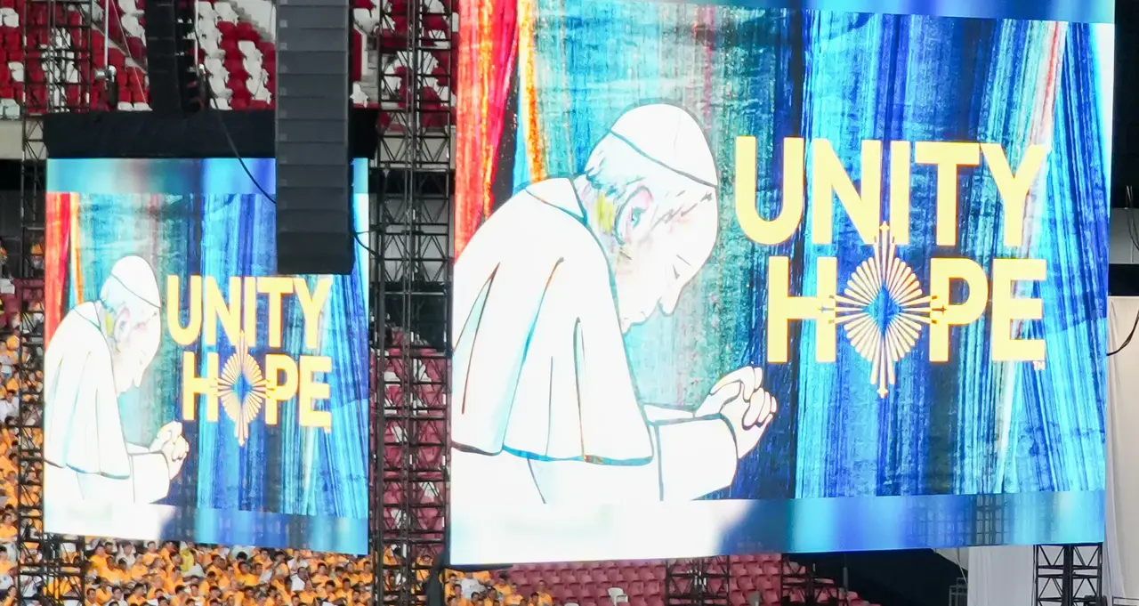 Two large screens display an illustration of a praying figure with the words "UNITY" and "HOPE" in bold letters.