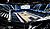 Indoor basketball arena featuring a polished court, surrounded by tiered seating and digital displays.