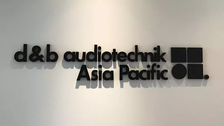 Signage displaying "d&b audiotechnik Asia Pacific" in bold, modern typography on a light background.