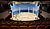 A theatrical performance featuring a conductor, an orchestra, and a choir on a multi-level stage, with performers in formal attire.