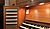 Wooden organ console featuring a keyboard, control buttons, and a sheet of music on display.
