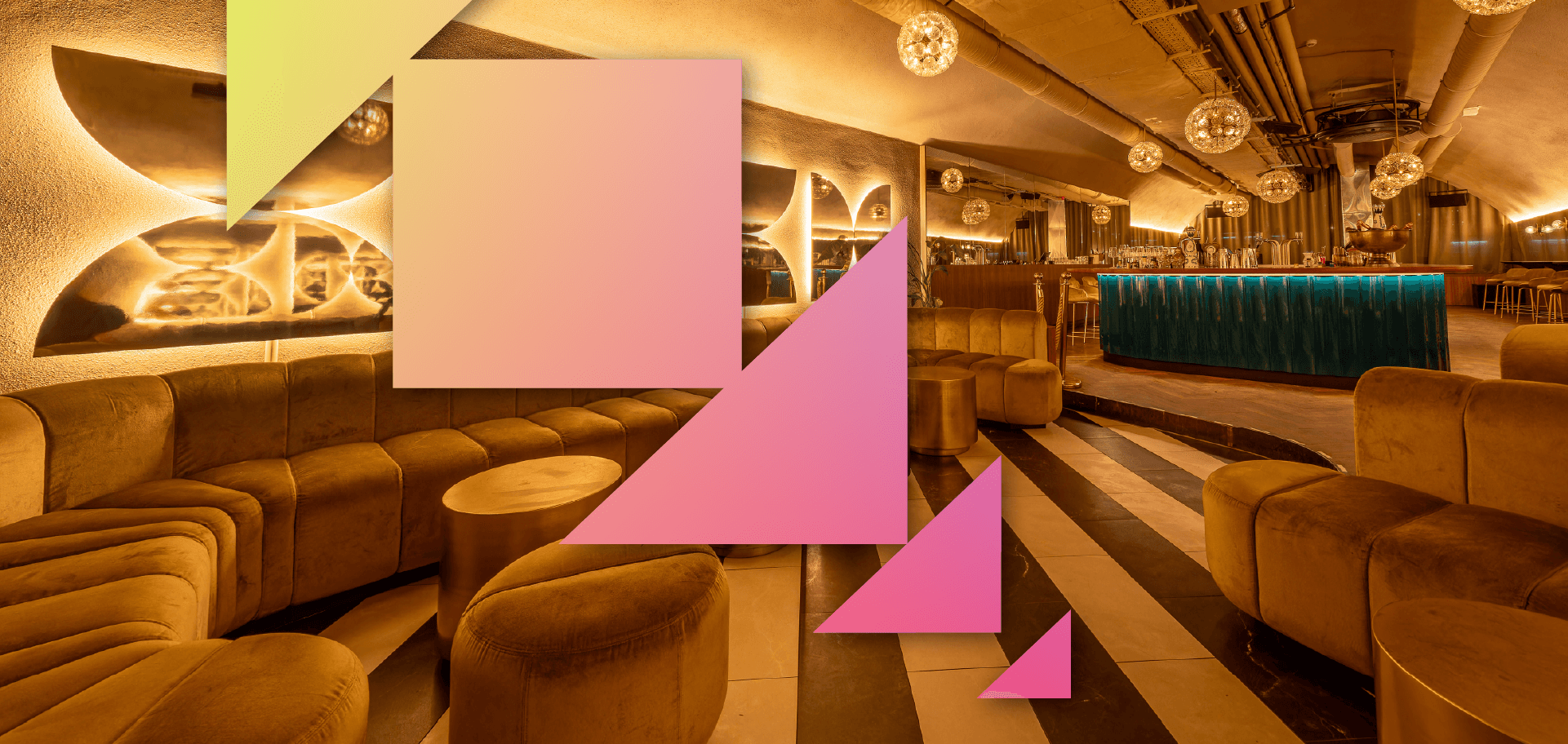 Stylish lounge interior featuring plush seating, modern lighting, and a bar with a teal front, accented by geometric shapes in vibrant colors.