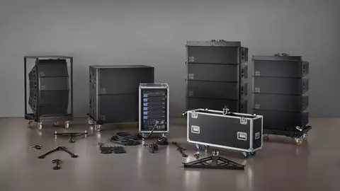 Audio-Ausrüstung mit mehreren schwarzen Lautsprechergehäusen, einer Steuereinheit und verschiedenen Zubehörteilen vor einem neutralen Hintergrund.